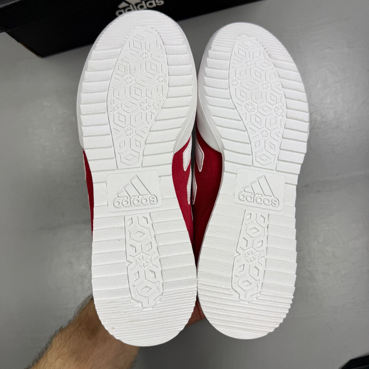 Adidas red suede running trainers with white logo and classic design details.