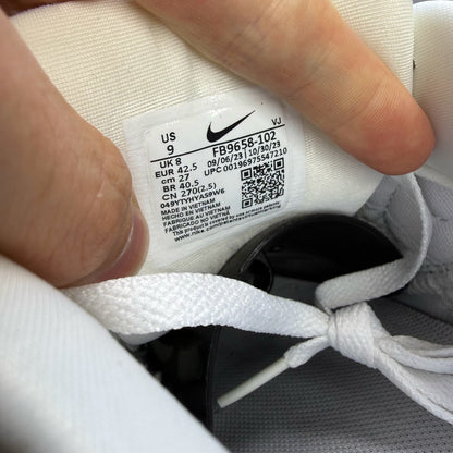 Nike Air Max 90 white trainers with green and black accents, featuring iconic logo details.