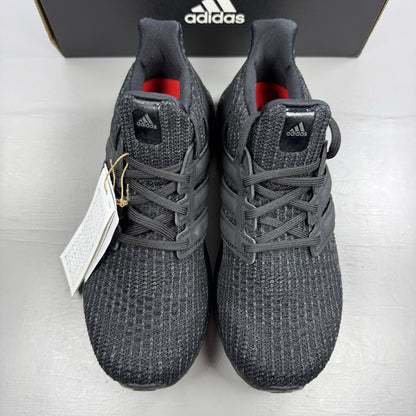 Adidas black trainers with grey accents and signature three-stripe logo.
