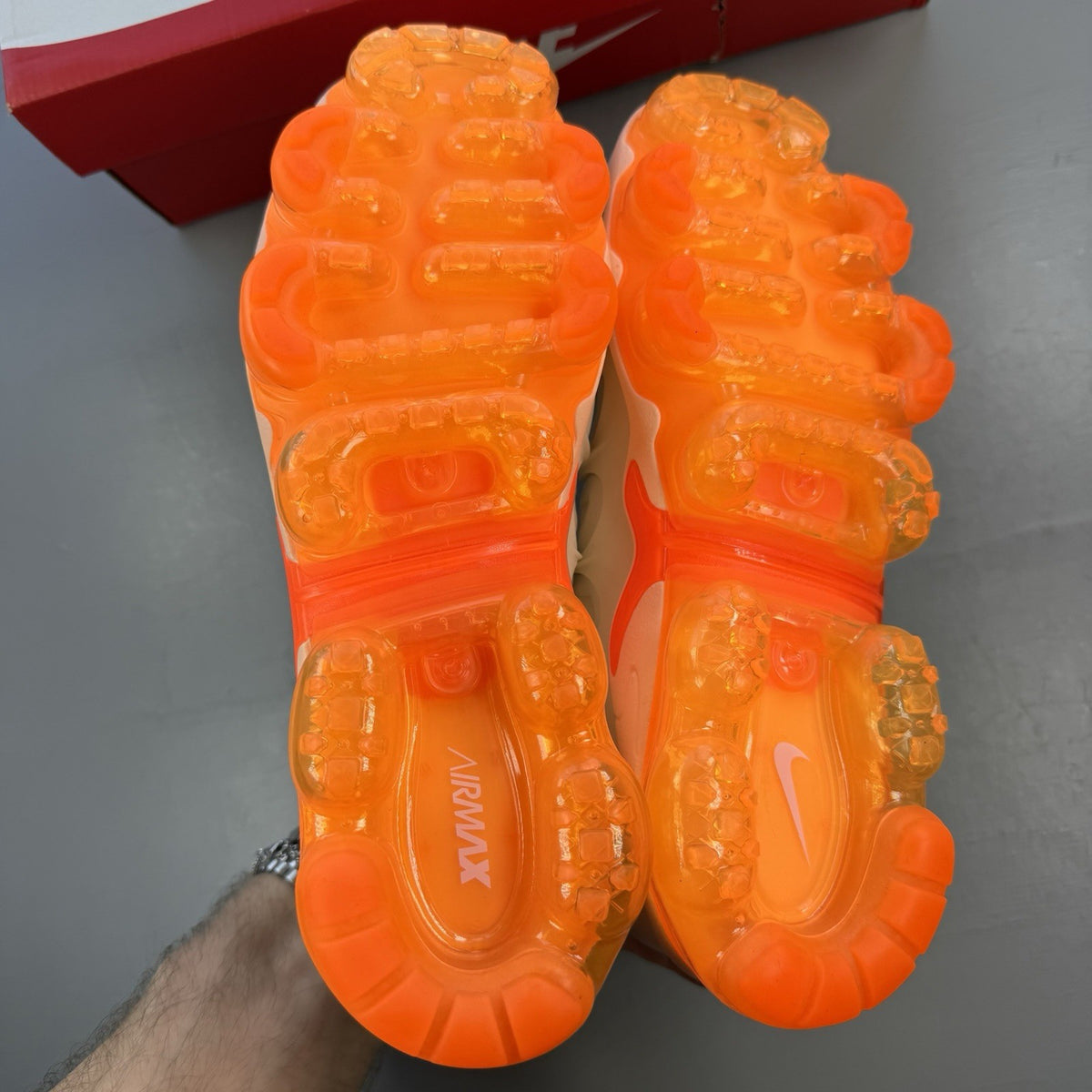 Nike Air VaporMax Plus beige trainers with Phantom Orange accents and distinctive logo.