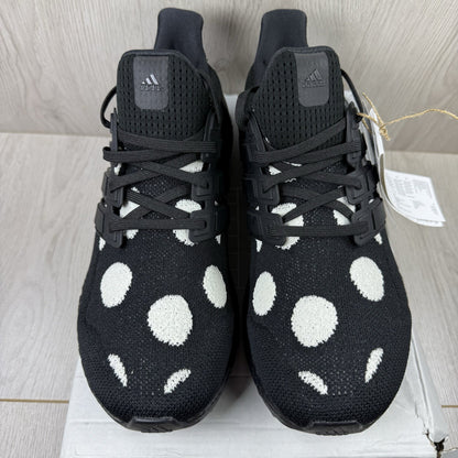 Adidas black trainers with white polka dot pattern and iconic three-stripe logo.