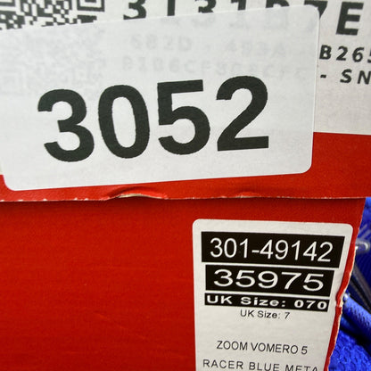 Nike Zoom Vomero 5 blue trainers with silver accents and logo detailing.