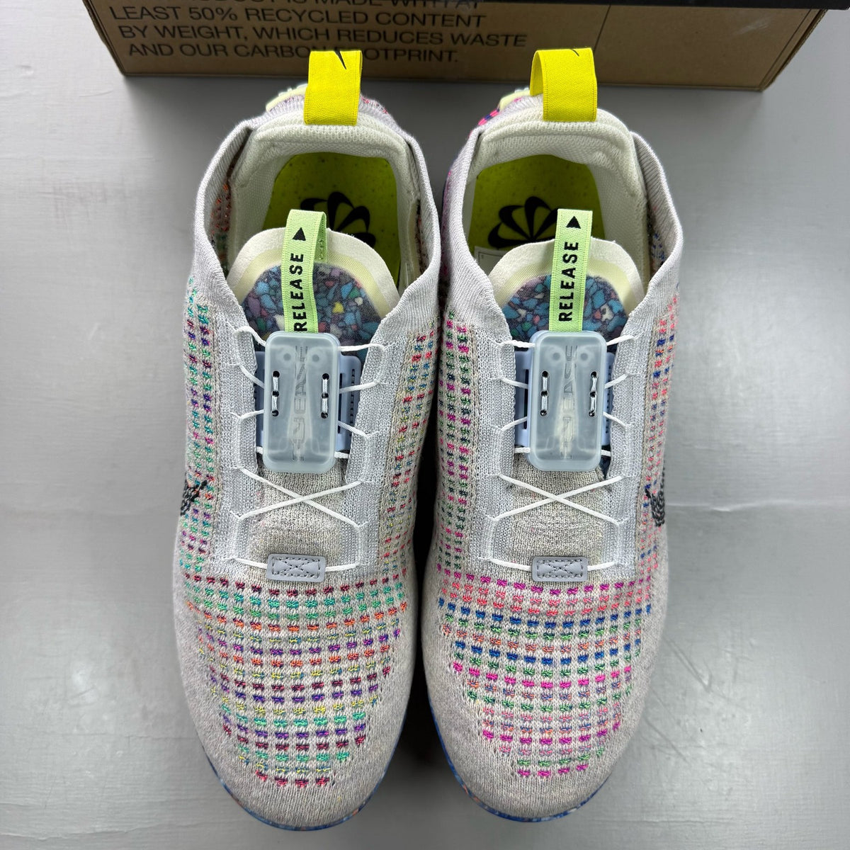 Nike multicolor Flyknit trainers in grey with distinctive air cushioning and logo detail.