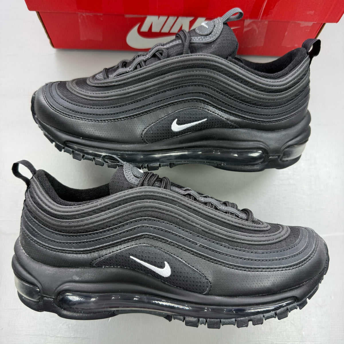 Nike Air Max 97 black trainers with anthracite accents and signature swoosh logo.