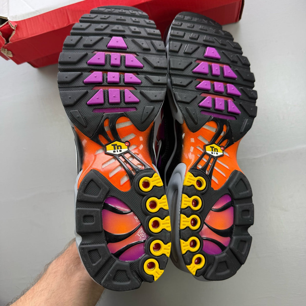 Nike Air Max Plus TN orange trainers with distinctive wave pattern and logo.