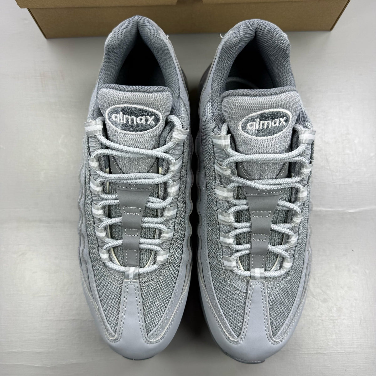 Nike Air Max 95 grey trainers with white accents and signature logo details.