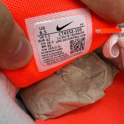 Nike trainers white with hyper orange accents and grey detailing, featuring iconic swoosh logo.