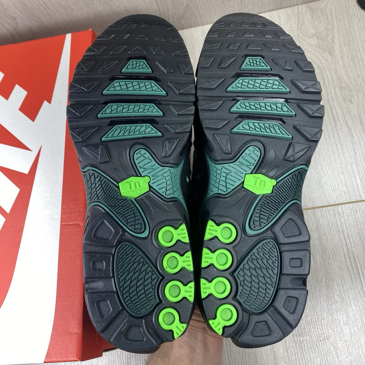 Nike Air Max Plus trainers black with volt green accents and signature swoosh logo.