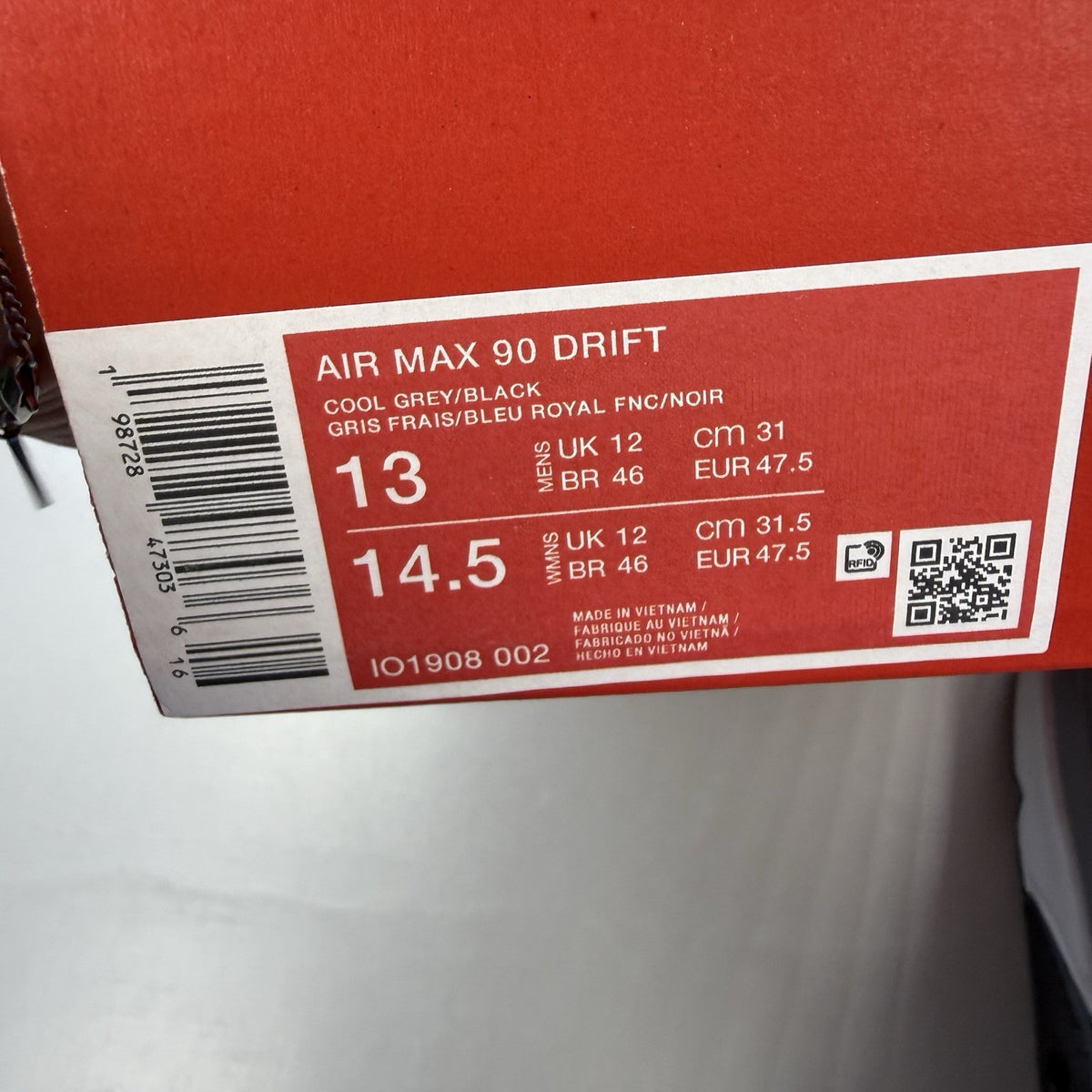 Nike Air Max 90 Drift grey trainers with deep royal blue accents and logo details.
