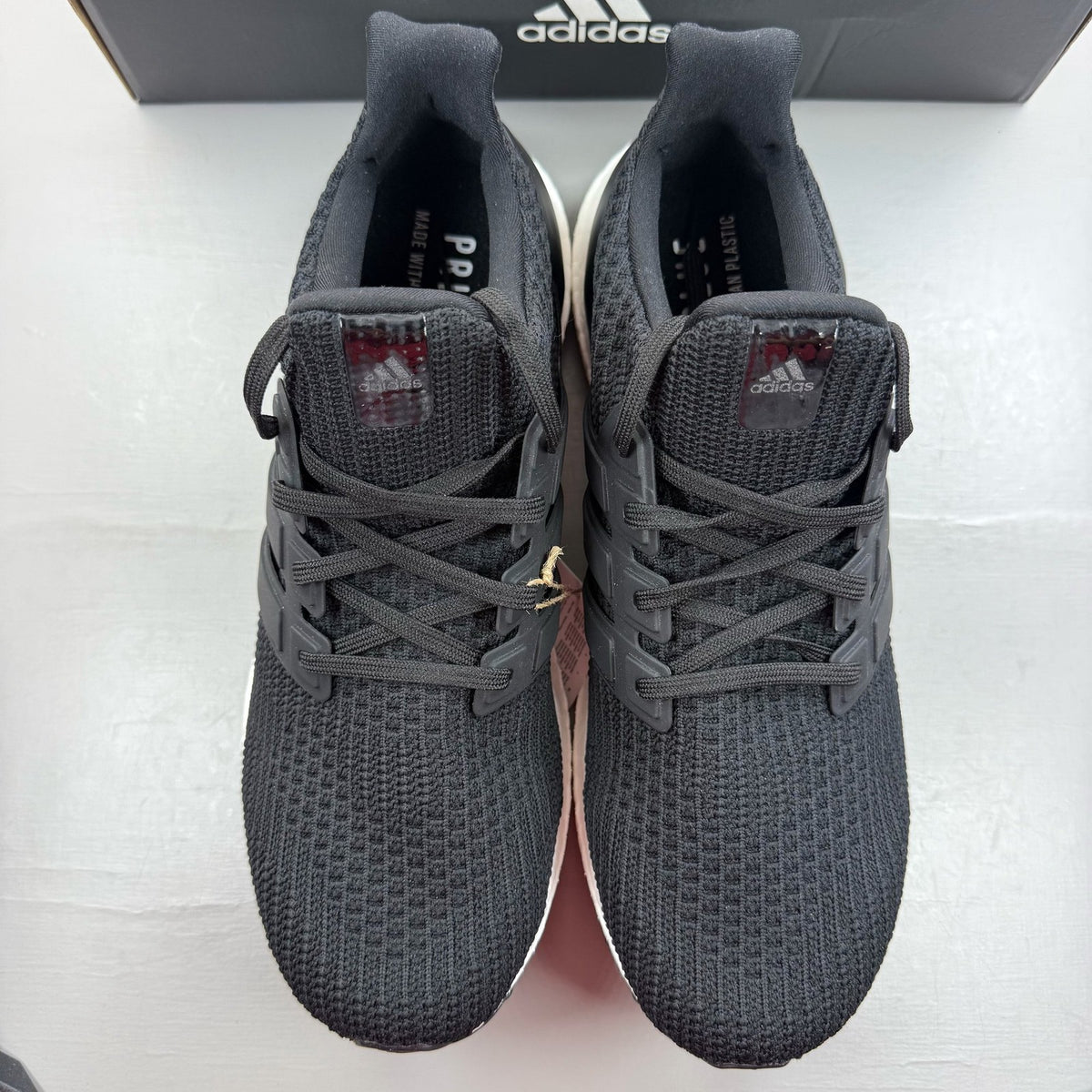 Adidas black Ultra Boost trainers with white accents and signature three-stripe logo.
