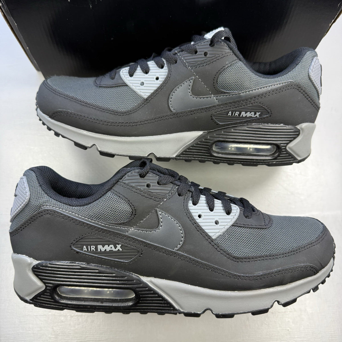 Nike Air Max 90 black trainers with anthracite and cool grey accents, iconic logo.