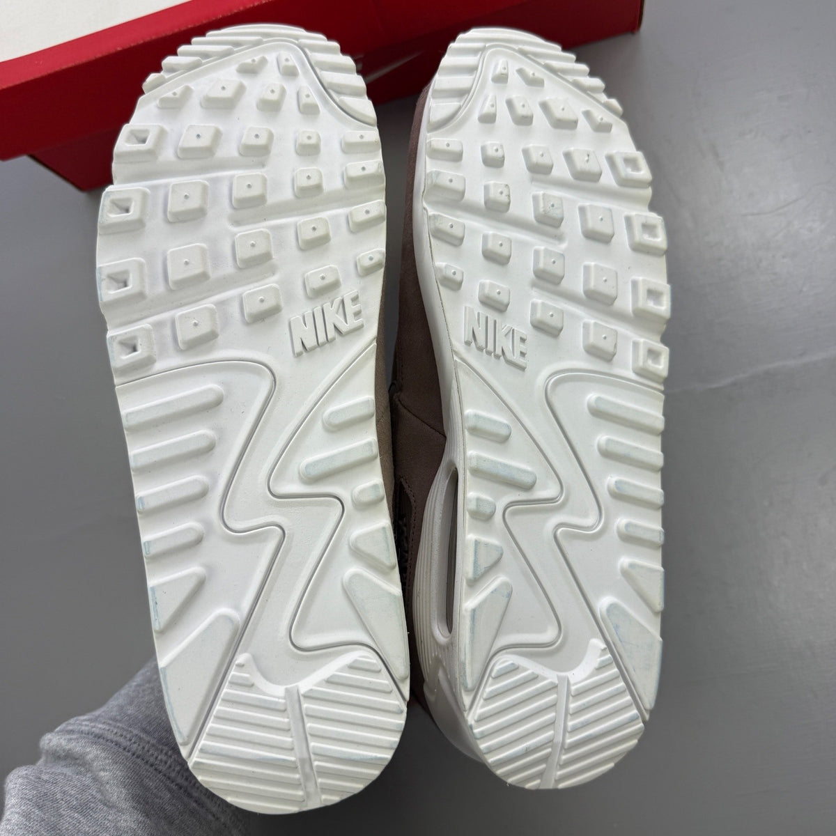 Nike beige trainers with Air Max cushioning and logo detailing.