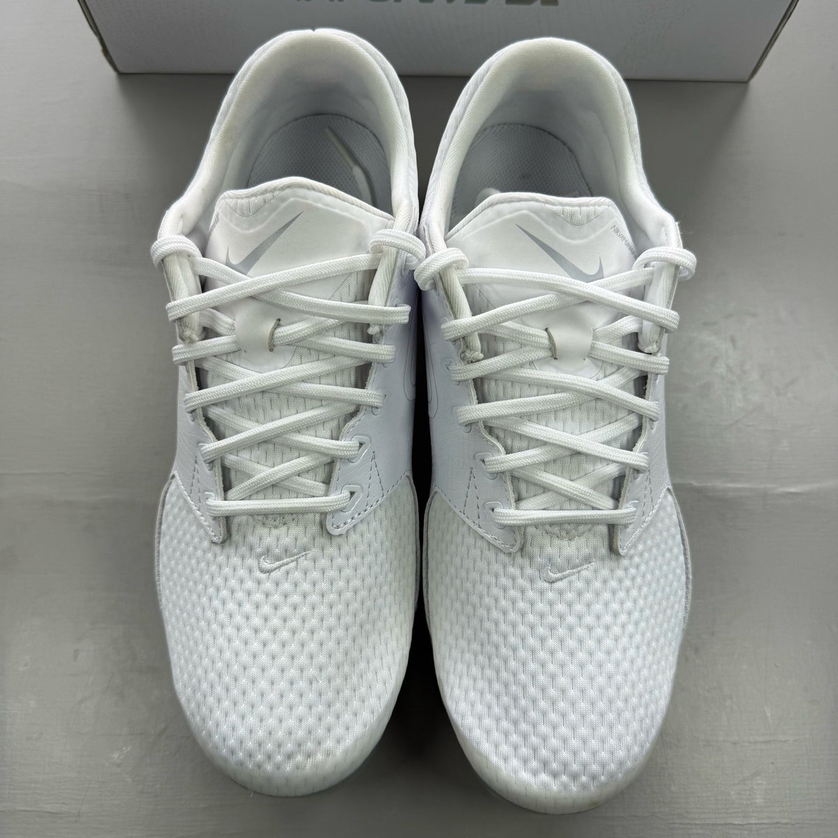 Nike white trainers with gum sole and silver accents, featuring breathable mesh upper.