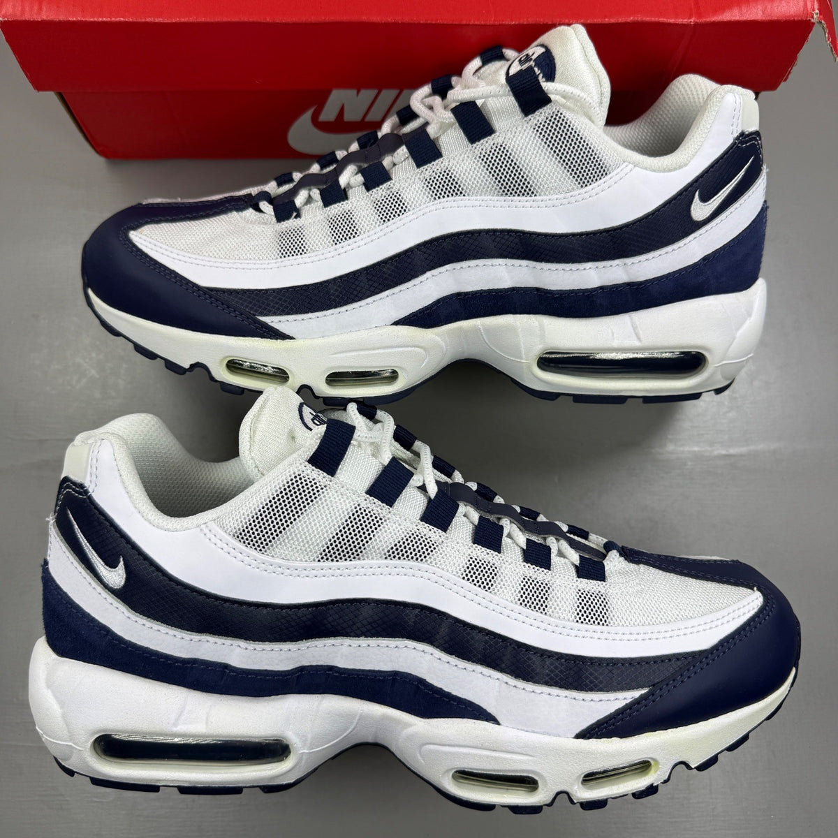 Nike Air Max 95 white trainers with navy accents and signature logo detailing.