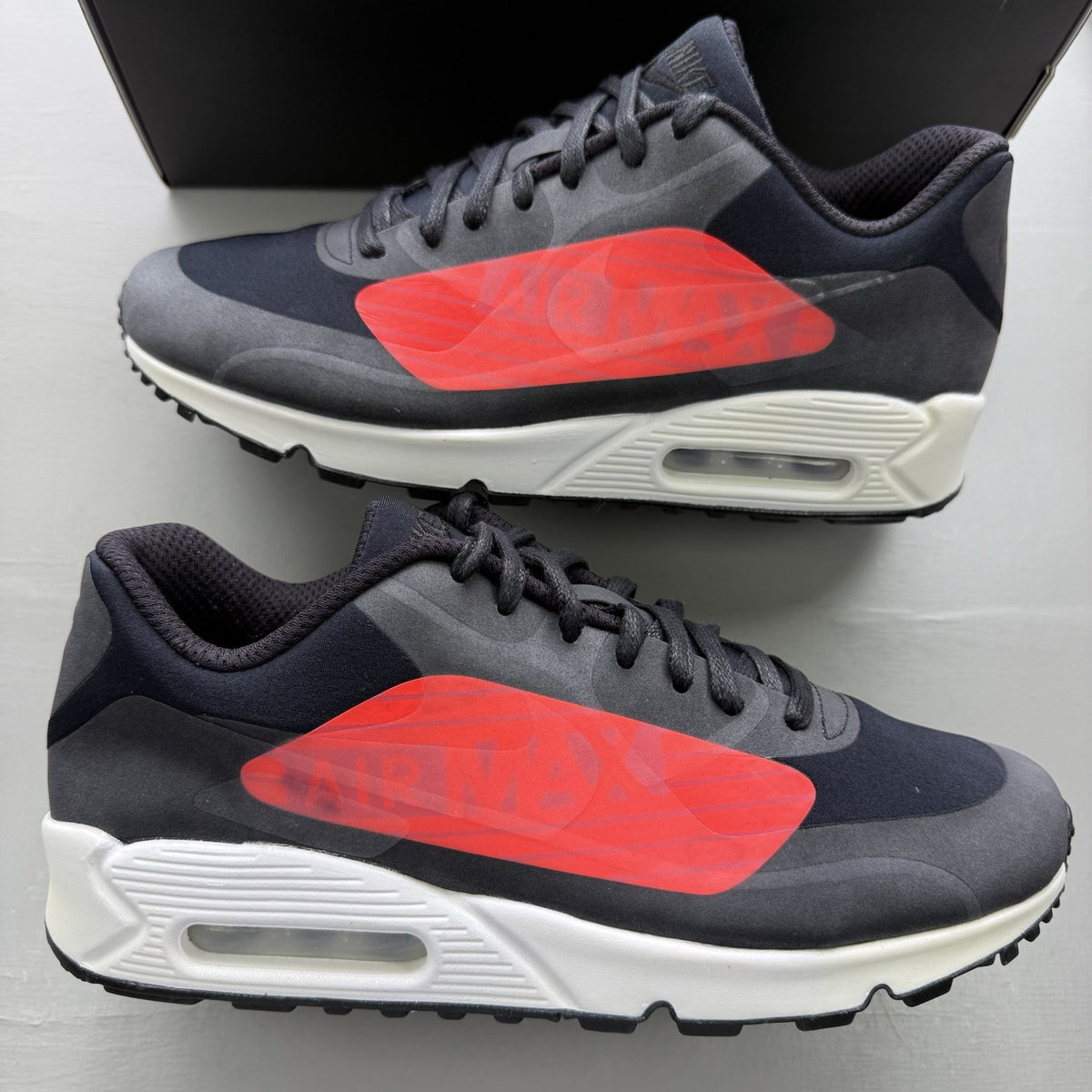 Nike Air Max 90 trainers black with crimson and white big logo design.
