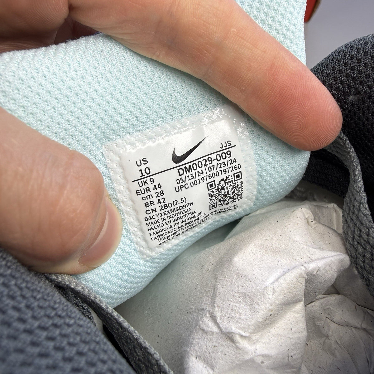 Nike Air Max 90 grey trainers with blue and white accents, featuring iconic logo.