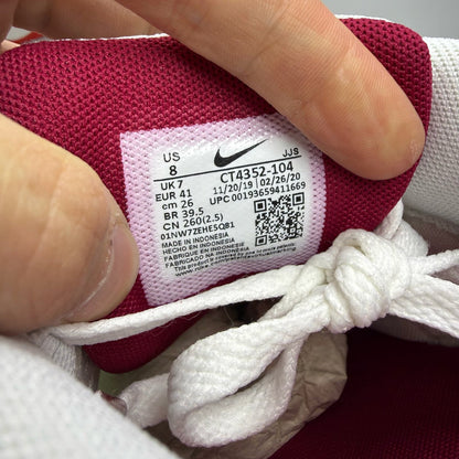 Nike Air Max 90 Recraft white trainers with maroon accents and logo detail.