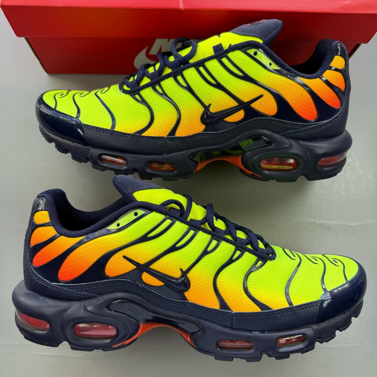 Nike Air Max Plus trainers yellow with Hyper Crimson accents and iconic TN logo.