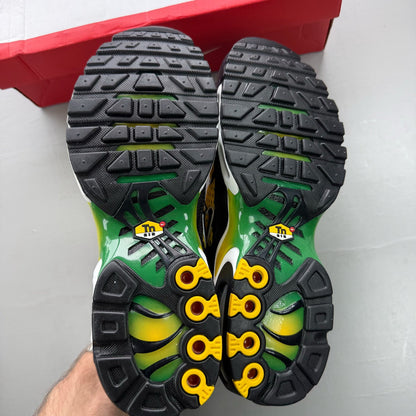 Nike black trainers featuring Air Max Plus design and vibrant yellow accents.