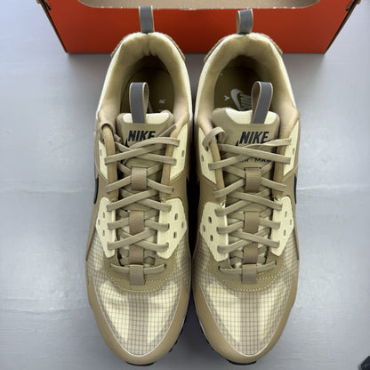 Nike Air Max 90 Drift beige trainers with white accents and logo detailing.
