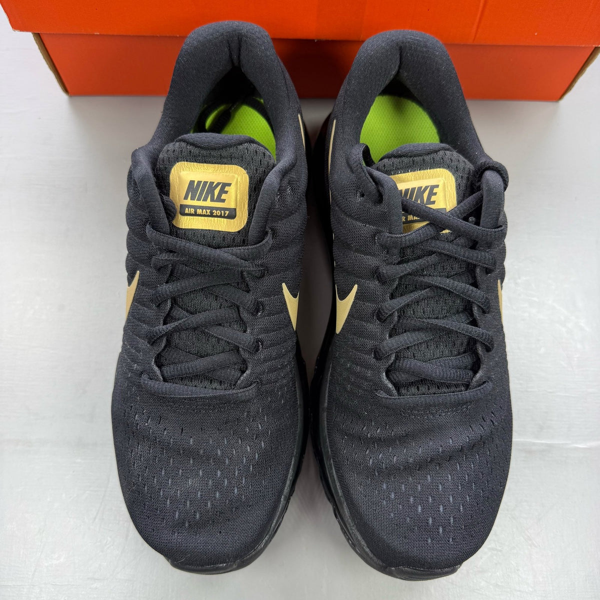 Nike Air Max 2017 GS trainers black with metallic gold accents and logo detail.
