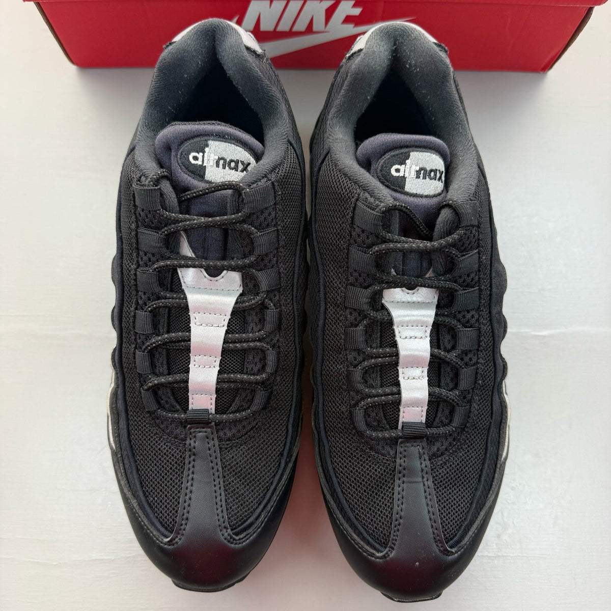 Nike Air Max 95 black sneakers with metallic silver accents and big bubble sole design.
