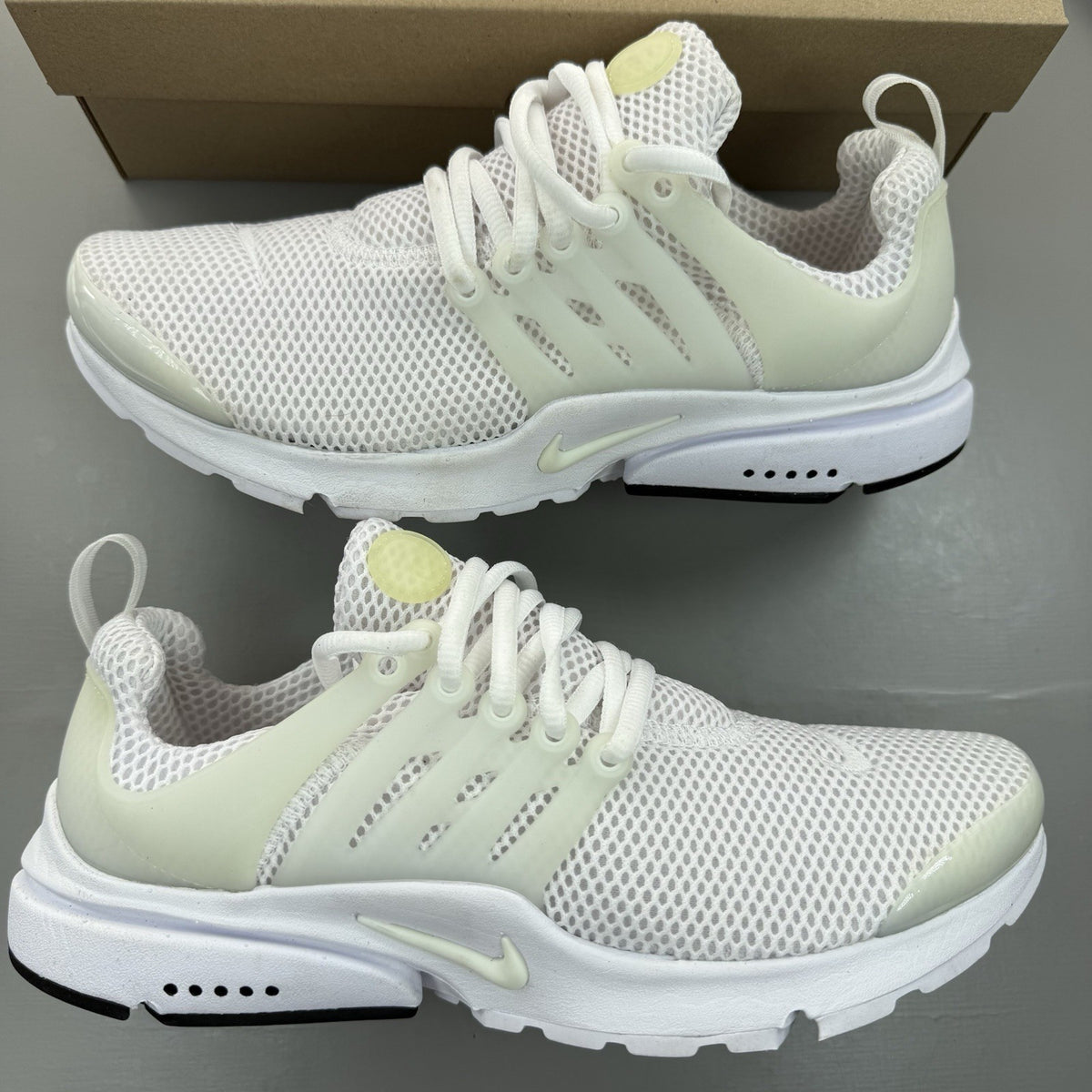 Nike Air Presto white trainers with black accents and mesh upper.