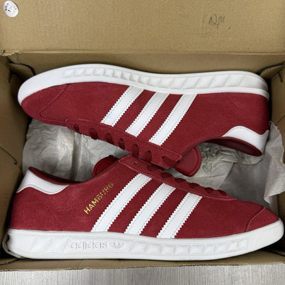 Adidas red trainers with white stripes and logo, classic suede material.
