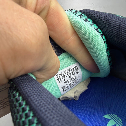 Adidas ZX Flux green trainers with woven texture and night navy accents.