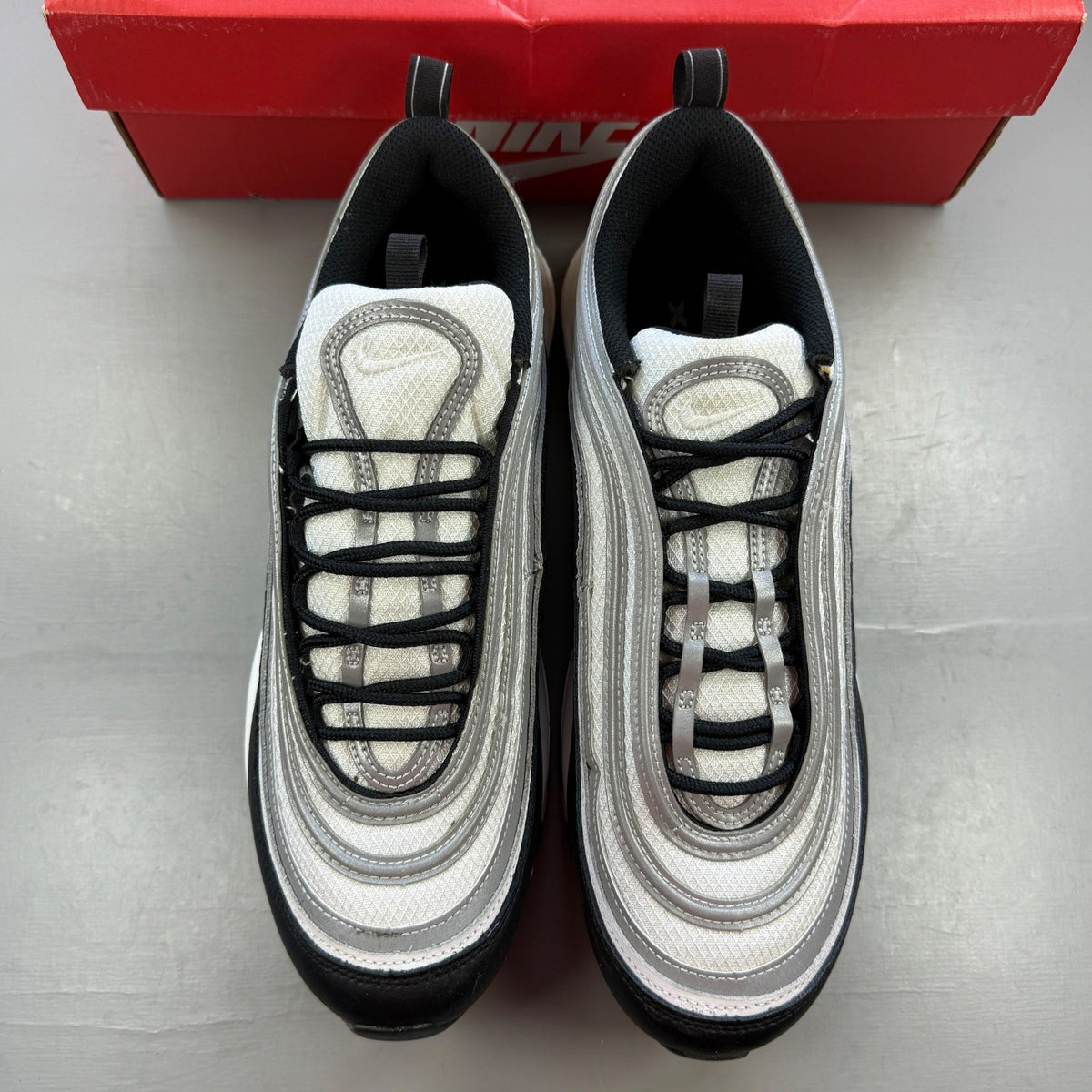 Nike black athletic shoes with metallic silver accents and signature logo detailing.