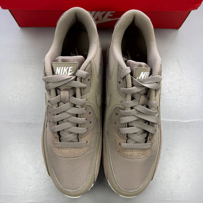 Nike beige trainers with Air Max cushioning and logo detailing.