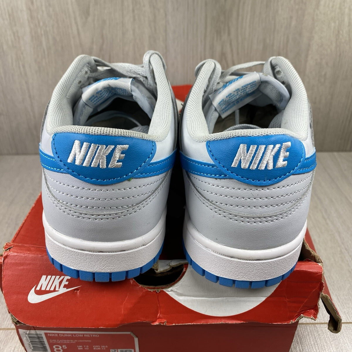 Nike Dunk Low Retro grey with blue accents and signature swoosh logo.