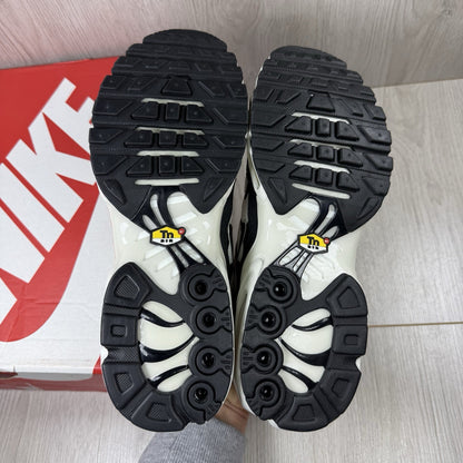 Nike Air Max Plus TN ESS trainers white with black accents and signature swoosh logo.