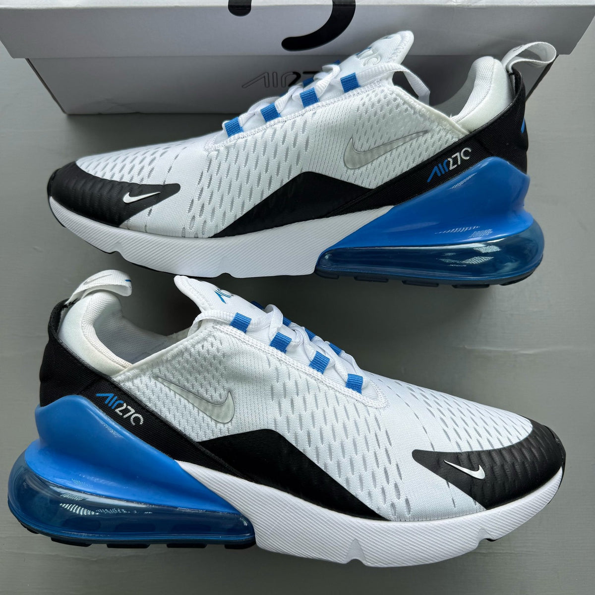 Nike Air Max 270 white trainers with laser blue accents and logo detail.