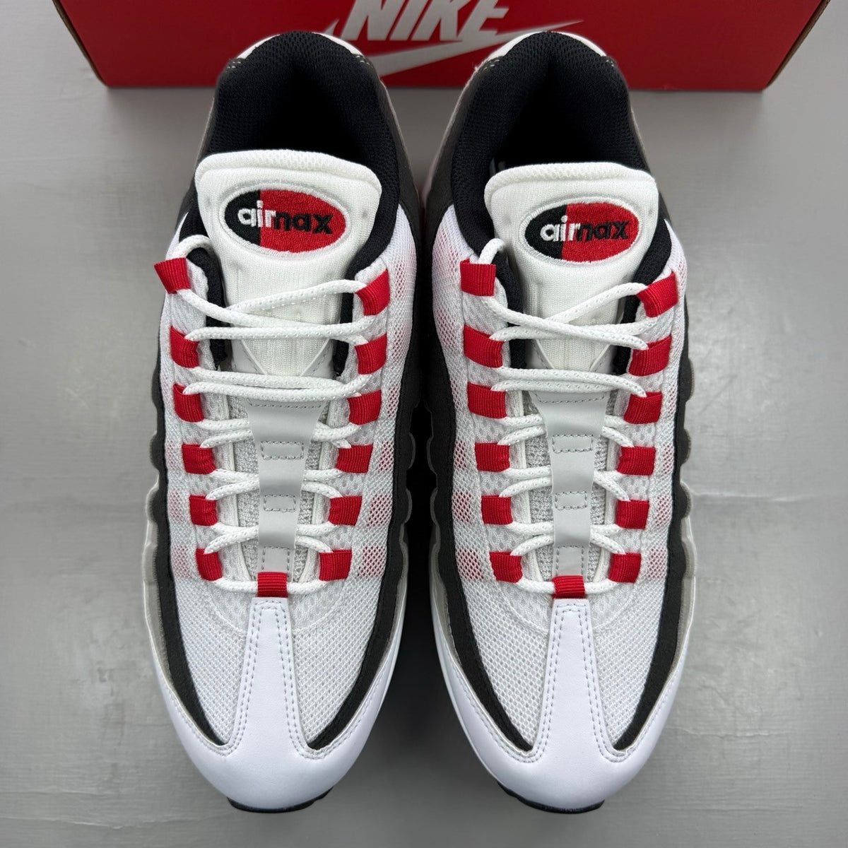 Nike trainers white with red accents and iconic Air Max bubble sole.