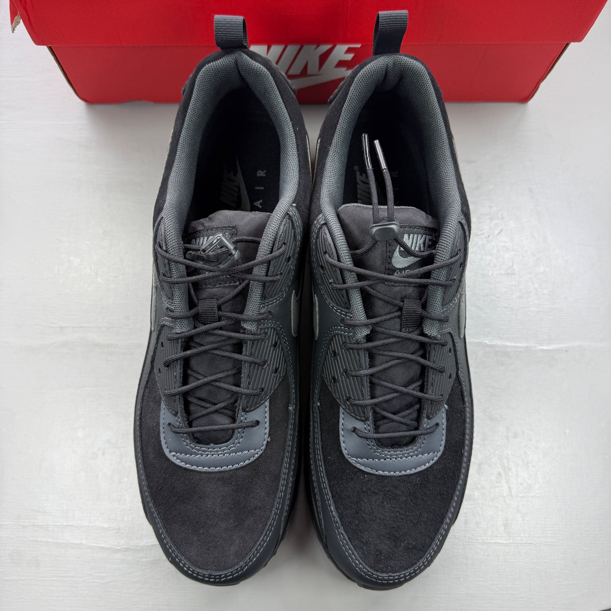 Nike black trainers with grey accents and Air Max cushioning detail.