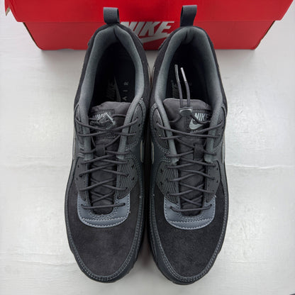 Nike black trainers with grey accents and Air Max cushioning detail.