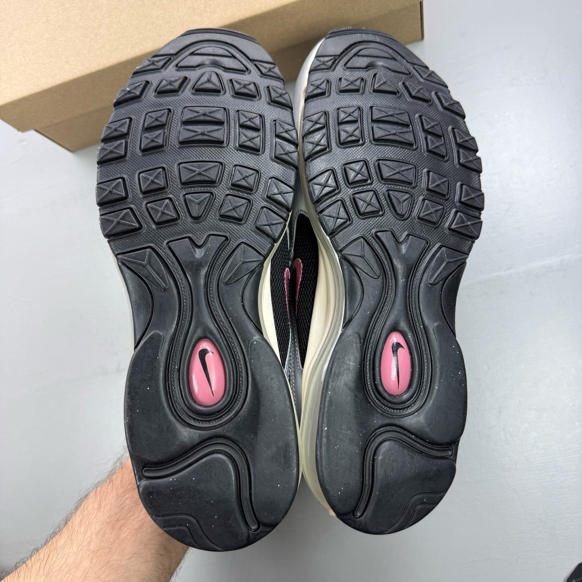 Nike Air Max 97 metallic silver trainers with berry accents and signature swoosh logo.