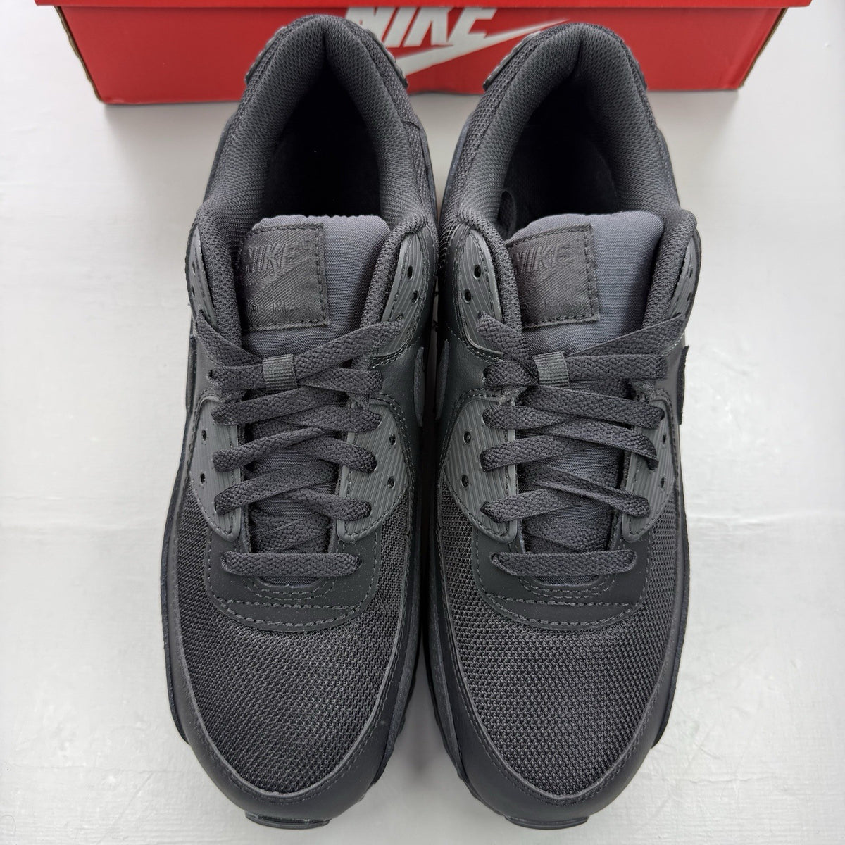Nike Air Max 90 Recraft black trainers with textured upper and signature swoosh logo.