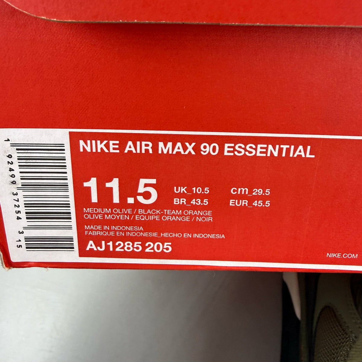 Nike Air Max 90 green trainers with black accents and classic logo detail.