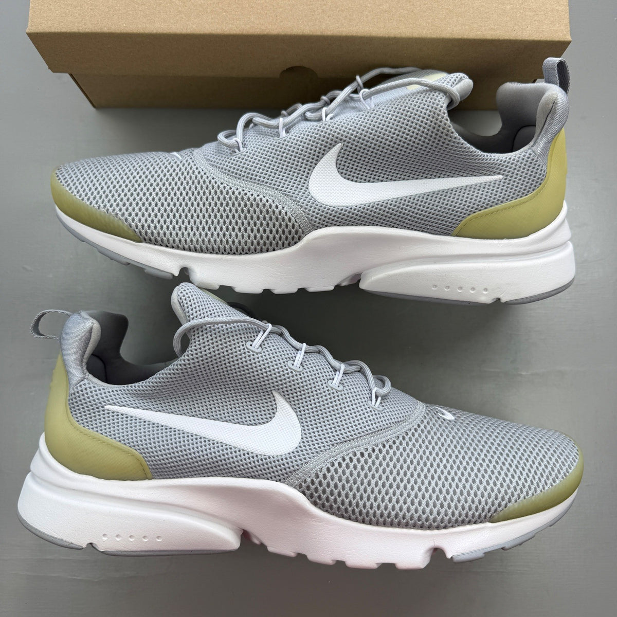 Nike running shoes grey mesh upper with white sole and logo detail.