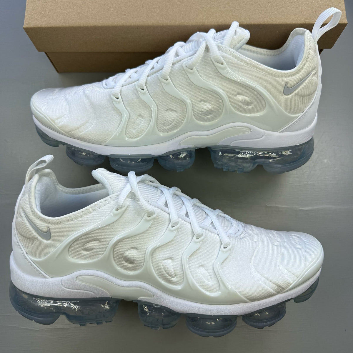 Nike white trainers with Pure Platinum accents and signature logo detailing.