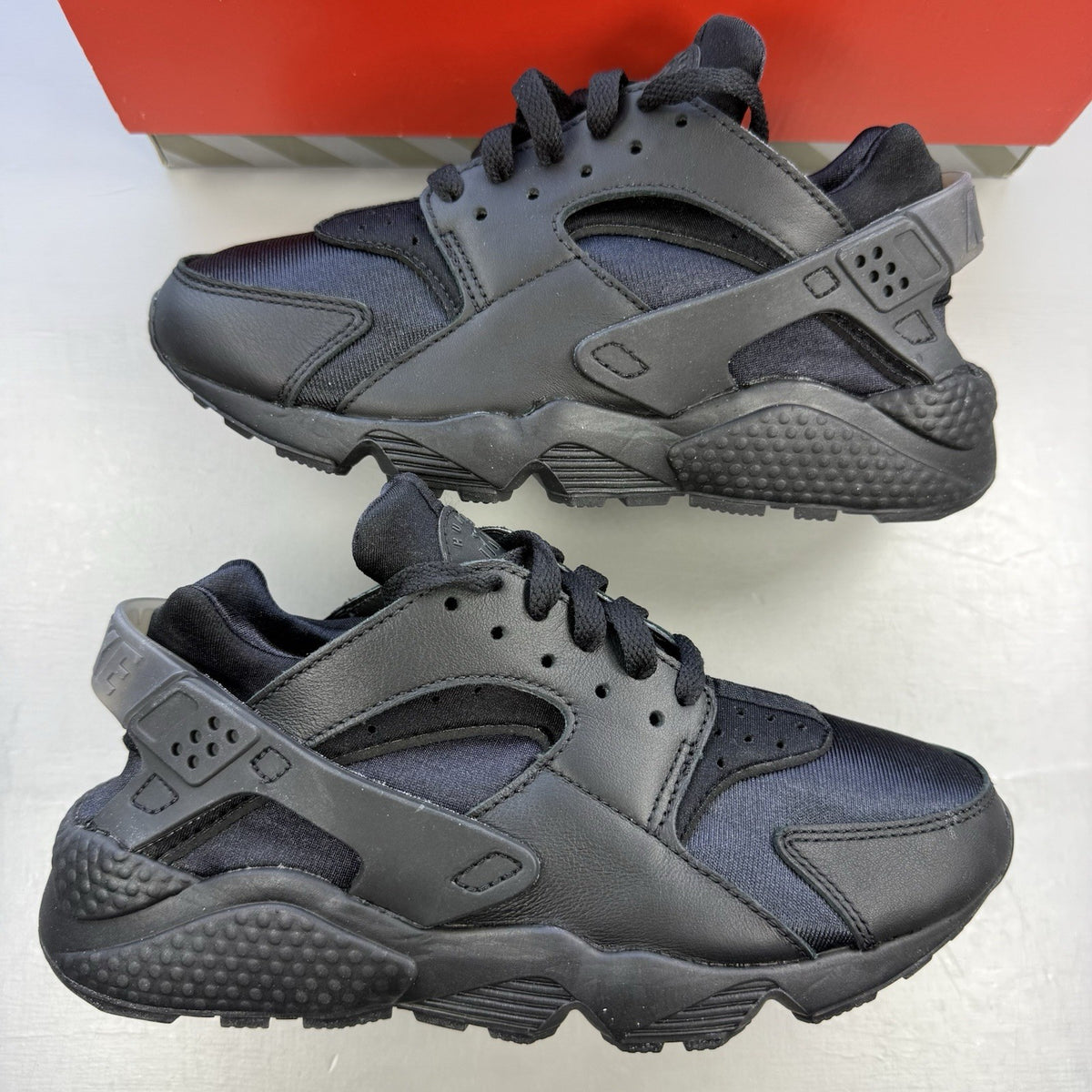 Nike black Air Huarache trainers with anthracite heel tab and distinctive design.