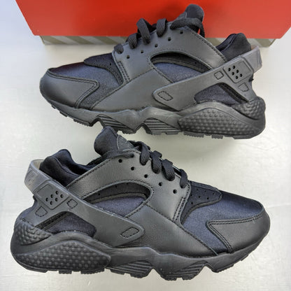 Nike black Air Huarache trainers with anthracite heel tab and distinctive design.