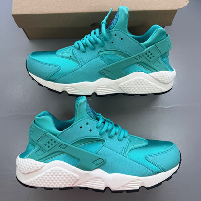 Nike Air Huarache blue trainers with retro design and cushioned sole.