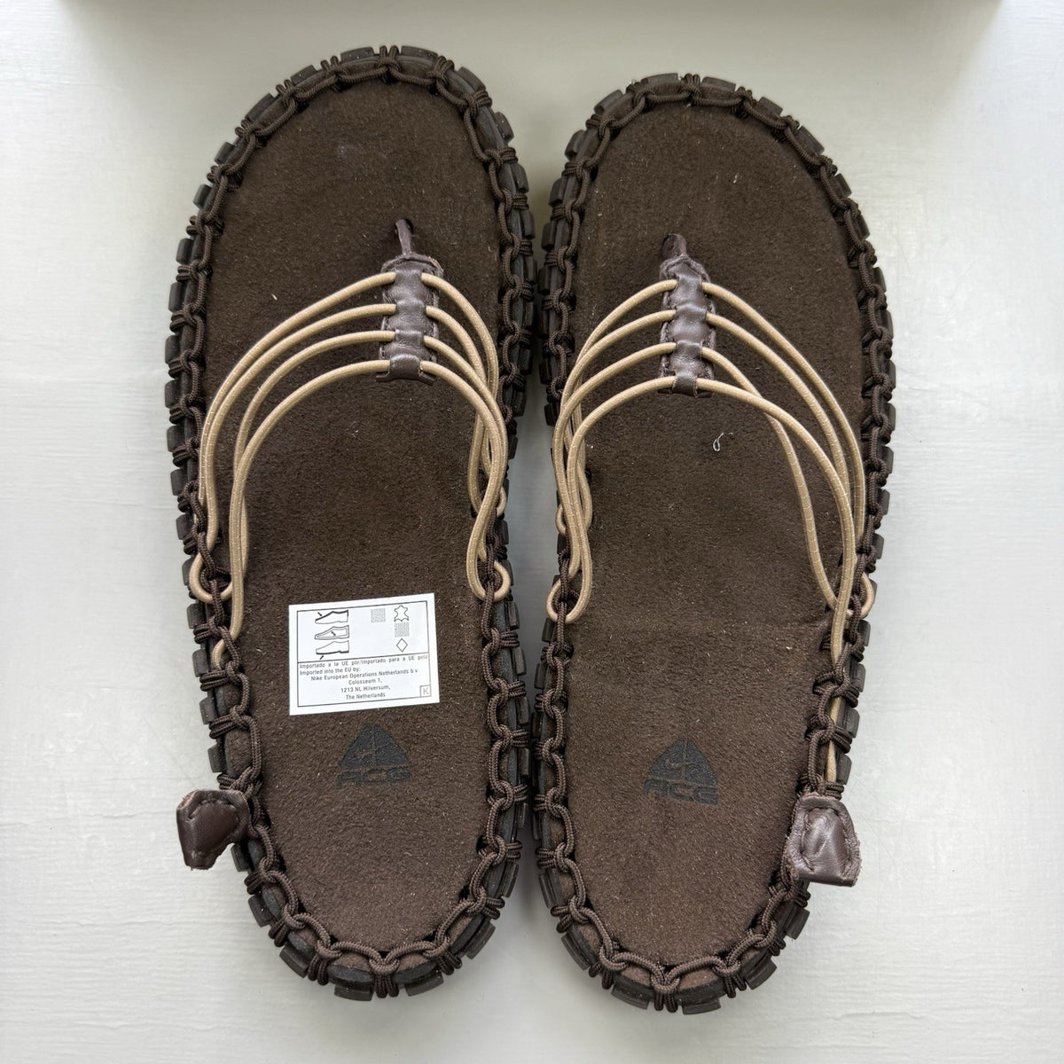 Nike ACG Valkyrie CI slides dark cinder brown with logo detail and textured material.