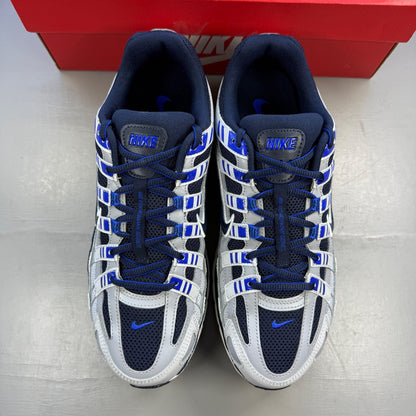 Nike P-6000 grey trainers with blue and white accents, featuring logo detail.