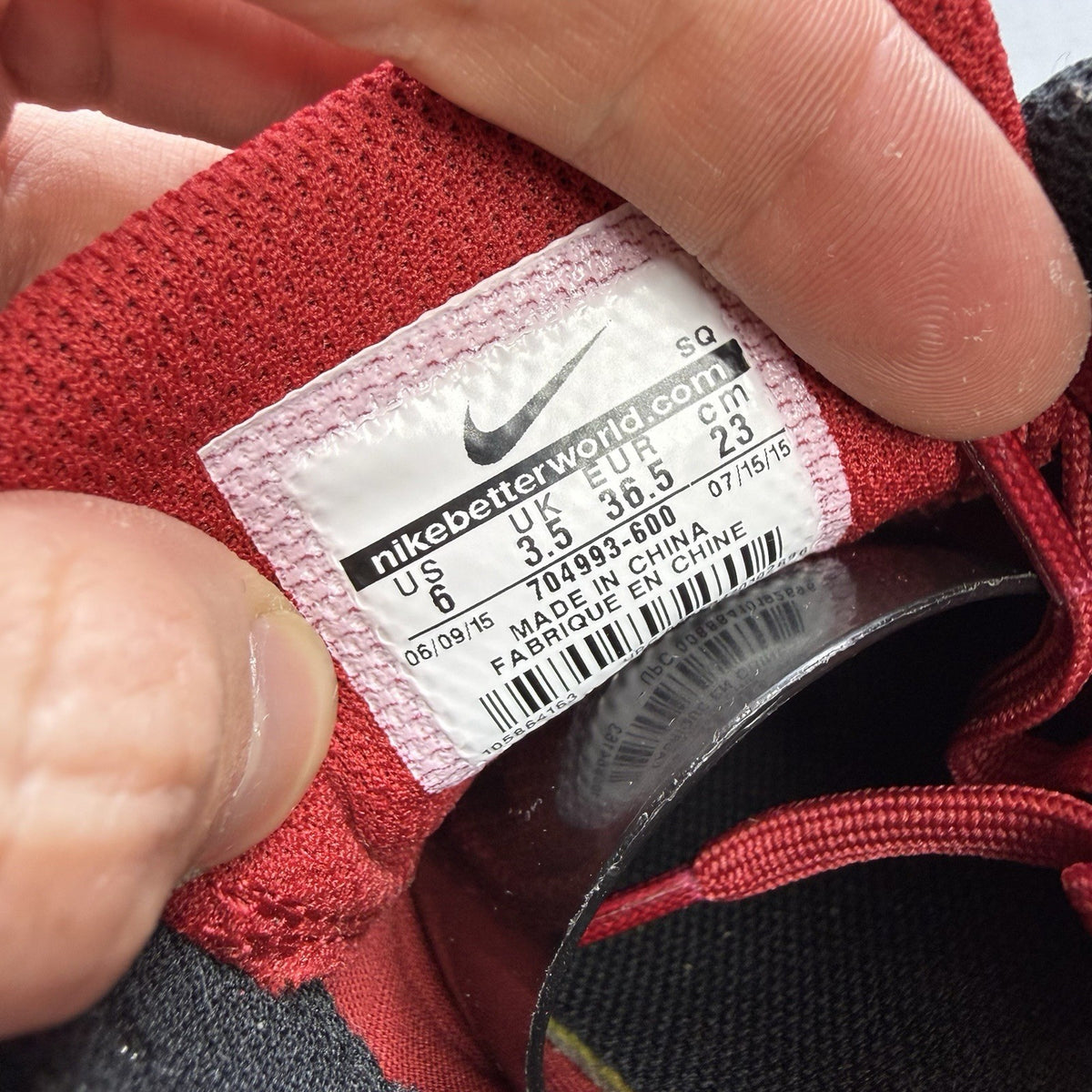 Nike Air Max 1 Ultra Essential red trainers with white and black accents, logo detail.