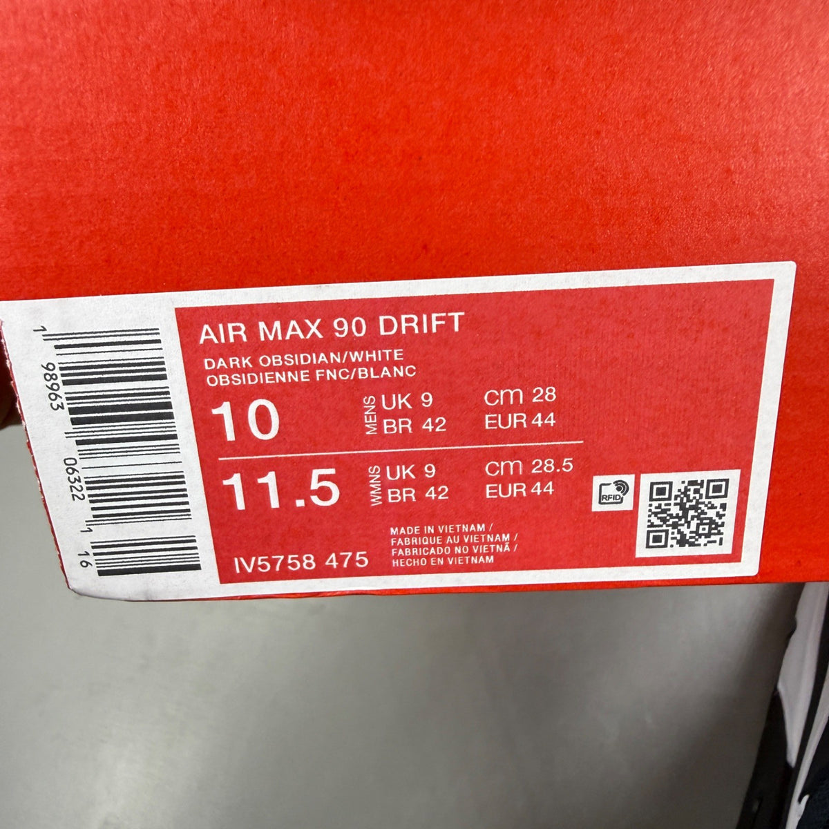 Nike Air Max 90 blue trainers with dark obsidian accents and signature swoosh logo.