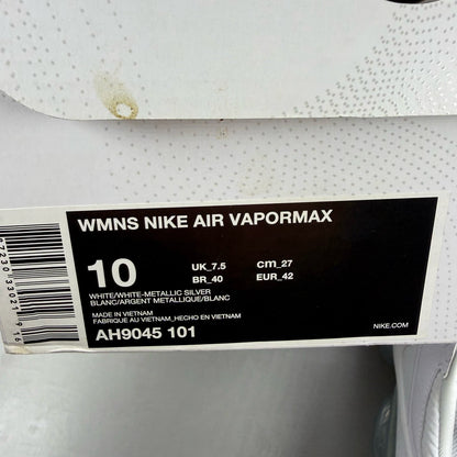 Nike white trainers with gum sole and silver accents, featuring breathable mesh upper.